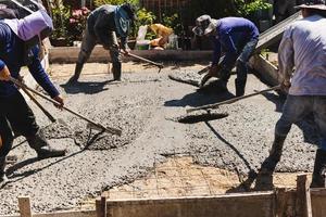 arbeiders afrekenen en niveau de beton in de fundament. foto