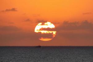 zon schijf stijgende lijn over- de horizon van de zee, zonsopkomst, dageraad foto