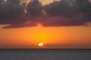 zon schijf stijgende lijn over- de horizon van de zee, zonsopkomst, dageraad foto