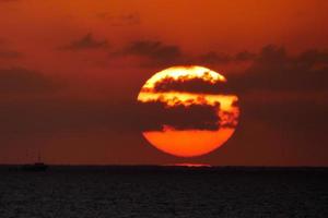 zon schijf stijgende lijn over- de horizon van de zee, zonsopkomst, dageraad foto