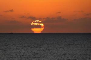 zon schijf stijgende lijn over- de horizon van de zee, zonsopkomst, dageraad foto