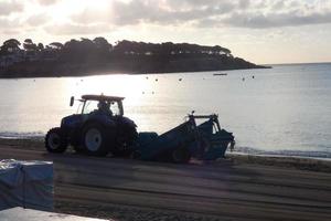 trekker schoonmaak de wit zand Aan de strand foto