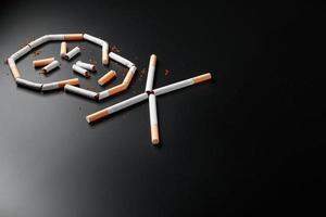 schedel van sigaretten Aan een zwart achtergrond. de concept van roken doodt. richting de concept van roken net zo een dodelijk gewoonte, nicotine vergiften, kanker van roken, ziekte, stoppen roken. foto