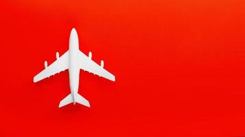 wit passagier model- vliegtuig Aan een helder rood achtergrond. vrij ruimte voor tekst foto