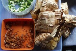 ketupat is Indonesië traditioneel voedsel. rijst- taart gekookt in een ruitvormig pakket van gevlochten jong kokosnoot bladeren. foto