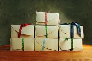 stapel witte geschenkdozen met linten op houten tafel. foto