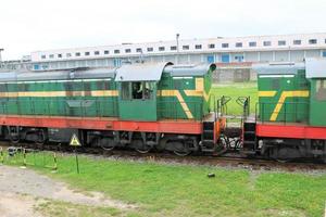 groen metalen ijzer op wielen vracht trein, locomotief voor de vervoer van goederen Aan rails Bij de spoorweg station foto