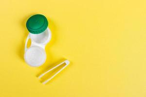 houder voor contact lenzen, pincet geel tafel foto