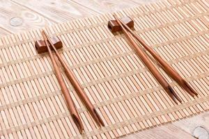 twee sets van sushi eetstokjes Aan houten bamboe achtergrond, top visie foto
