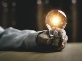 zakenvrouw Holding een licht lamp, creatief nieuw idee. innovatie, brainstormen, oplossing en inspiratie concepten. verbeelding, creatief denken probleem oplossen. foto