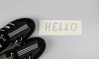 de woord Hallo Aan een wit achtergrond De volgende naar gewoontjes zomer schoenen.wereld groeten dag. de dag van winnend vrienden. foto