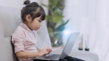 Aziatisch weinig meisje gebruik makend van de laptop. internet van dingen. edtech. foto