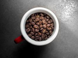 grond koffie Boon in een rood kop met natuur licht voor reclame koffie cafe of poster verkopen menu foto