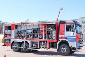 groot speciaal rood met blauw brand auto, motor naar redden mensen met Open zijden en blussen apparatuur, brand pomp, blazen tussenpersoon, hulpmiddel, water mouwen, slangen, ballonnen, uitrustingen foto