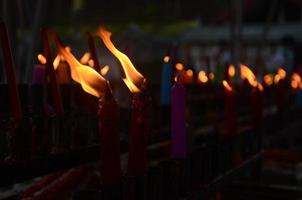 brandend rood kaars stokjes in kaars brander . kaars voor bidden Boeddha of Hindoe goden naar tonen aanbidding. foto