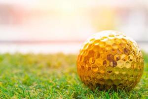 gouden golf bal Aan groen gras met wit ruimte voor tekst foto