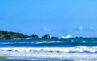 strand zand blauw water reusachtig surfer golven puerto escondido Mexico. foto
