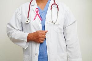 Aziatisch vrouw dokter met roze lint, wereld borst kanker dag Bij oktober. foto