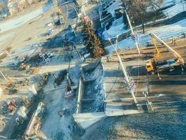 bouw van een nieuw viaduct in de stad centrum Aan een besneeuwd straat. dichtbij naar verkeer lichten en bezig verkeer. weg reparatie in de stad centrum foto