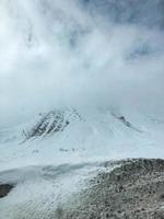 mooi berg verkoudheid winter toevlucht landschappen met hoog berg pieken de nevel en sneeuw gedekt rotsen voor snowboarden en skiën tegen een blauw lucht foto