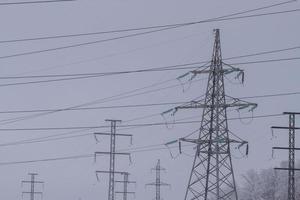 hoog voltage elektrisch transmissie torens in winter. foto