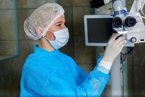 dokter in ademen masker chekken chirurgisch microscop in operatie kamer foto