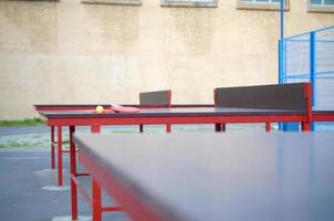 rackets en bal Aan ping pong tafel in buitenshuis sport tuin. actief sport- en fysiek opleiding concept foto