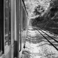 speelgoed- trein in beweging Aan berg helling, mooi visie, een kant berg, een kant vallei in beweging Aan spoorweg naar de heuvel, tussen groen natuurlijk bos.speelgoed trein van kalka naar shimla in india-zwart en wit foto