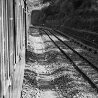 speelgoed- trein in beweging Aan berg helling, mooi visie, een kant berg, een kant vallei in beweging Aan spoorweg naar de heuvel, tussen groen natuurlijk bos.speelgoed trein van kalka naar shimla in india-zwart en wit foto