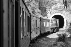 speelgoed- trein in beweging Aan berg helling, mooi visie, een kant berg, een kant vallei in beweging Aan spoorweg naar de heuvel, tussen groen natuurlijk bos.speelgoed trein van kalka naar shimla in india-zwart en wit foto