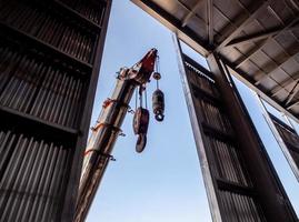 hijsen van kraan Bij de venster van industrieel fabriek foto