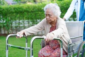 arts help aziatische oudere vrouw handicap patiënt lopen met rollator in verpleegziekenhuis, medisch concept. foto