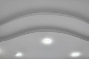 detail van hoek plafond met ingewikkeld kroon vormen. geschorst plafond en gipsplaat bouw in leeg kamer in appartement of huis. rekken plafond wit en complex vorm geven aan. foto