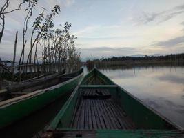 traditioneel houten boot drijvend Aan de wateren van meer limbo, gorontalo, Indonesië. klein houten roeiboot Aan een kalmte meer foto