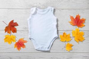 wit baby Onesie geïsoleerd over- licht hout achtergrond. mooi zo voor insert uw ontwerp foto