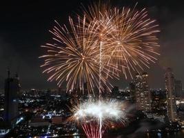 hoog hoek visie fantastisch veelkleurig lang blootstelling schot van vuurwerk over- chao phraya rivier, stadsgezicht van Bangkok, festival, viering, gelukkig nieuw jaar, bedrijf architectuur. foto