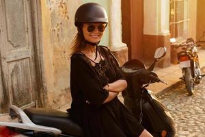 vrouw het rijden scooter door de oud stad straten foto