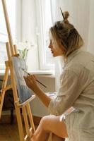 jong vrouw artiest schilderij Aan canvas Aan de ezel foto