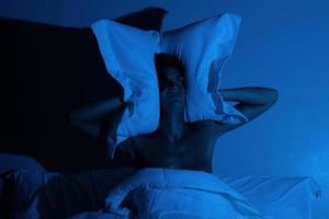 vrouw in de slaapkamer met een hoofdkussen Aan haar hoofd foto