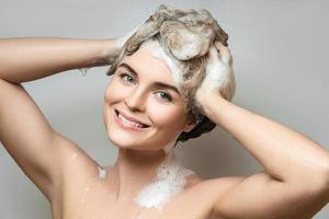 jong mooi vrouw is het wassen haar haar- met een shampoo foto