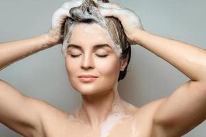 jong mooi vrouw is het wassen haar haar- met een shampoo foto