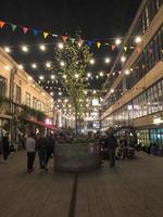 mensen wandelen langs de modern voetganger nacht straat met vlaggen en bollen, boetieks met cafés, bars en restaurants in de stad centrum. Georgië, batoemi, april 17, 2019 foto