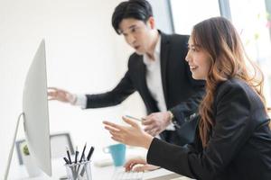 bedrijf mensen zittend samen Bij een bureau gebruik makend van laptops in de kantoor foto