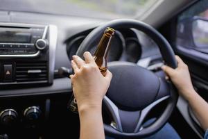 Mens drinken alcohol terwijl het rijden in zijn auto foto