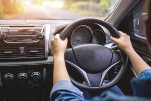 detailopname van een vrouw hand- Holding de stuurinrichting wiel van een auto. foto