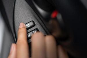 vrouw hand- drukken een auto venster slot knop foto