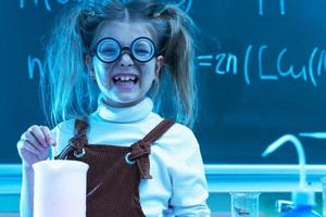 schattig weinig meisje gedurende chemie les in school- foto