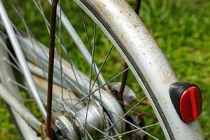 detailopname van een achterzijde wiel van een roestig haveloos wijnoogst fiets. foto