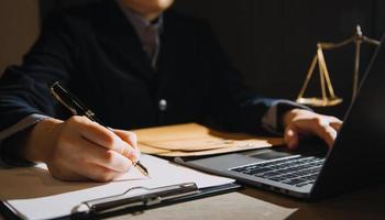 zaken en advocaten bespreken contractpapieren met koperen schaal op bureau in kantoor. wet, juridische diensten, advies, rechtvaardigheid en wet concept foto met film grain effect