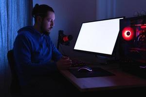 Mens werken Aan modern pc Bij nacht in de kamer met neon licht. blanco toezicht houden op scherm voor ontwerp. foto